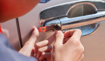 Close-up Of Person's Young Man Locksmith Hand Opening Bronze Car Door With Lock picker. Locksmith door opening device